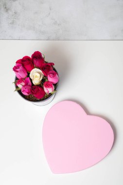 Süslü kovada güller ve bir kalp kutusu. Tatil, yıldönümü, doğum günü acil servisi için tebrikler.