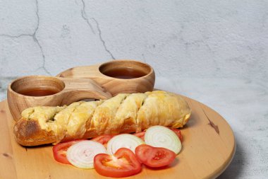 Lezzetli kızarmış sarımsaklı ekmek krem peynirle süslenmiş taze soğan ve domates.