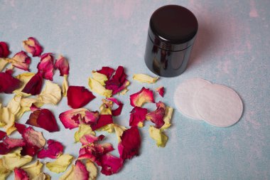 Dry rose petals, cream bottle, cotton swabs ER