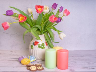 Bir buket çiçek. Laleler yakın plan. Farklı renklerde. Paskalya yumurtaları, mumlar. Kartpostal, Bahar ve Mutlu Paskalyalar