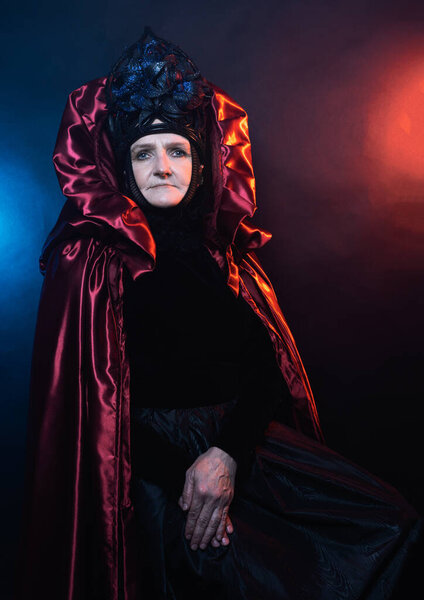 Fairy creature, historical character, fantasy queen, witch, in fairy costume Woman, model after 60, in the studio, dark background