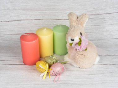 Tavşanın etrafında renkli yumurtalar ve mumlar Mutlu Paskalyalar. Bahar sezonu. Mutlu Paskalya bayrağı ışık arkaplanı.