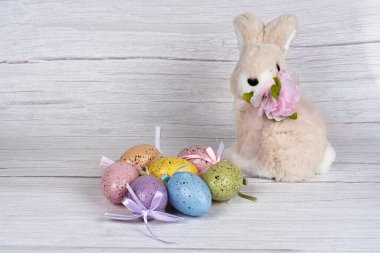 Tavşanın etrafında renkli yumurtalar Mutlu Paskalyalar. Bahar sezonu. Mutlu Paskalya bayrağı ışık arkaplanı.