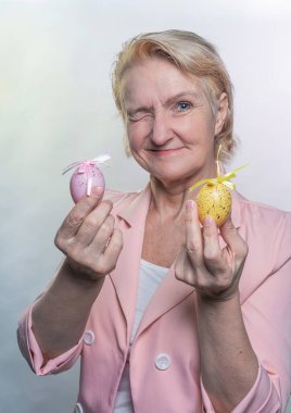 Neşeli, olgun, pembe ceketli zarif kadın.