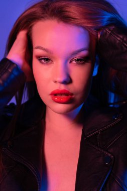 Uzun saçlı genç bir kızın portresi, yakın plan. Neon ışıkta fotoşop