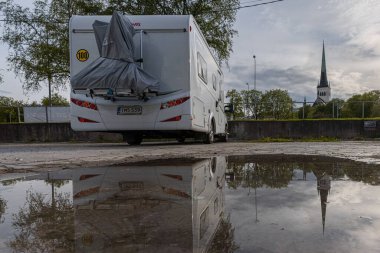 Tallinn Estonya 21 Mayıs 2021 Bir motorlu taşıt karavanı, bir karavan, otoparkta duruyor. Su birikintisindeki yansıma.