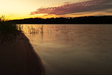 Denizde erken gün doğumu. Deniz suyuna yansıyan güneş ışınları. Suyun üzerinde parlıyor. Doğal deniz suyu arka planı. SANDINAVİYA 'NIN doğası. Finlandiya
