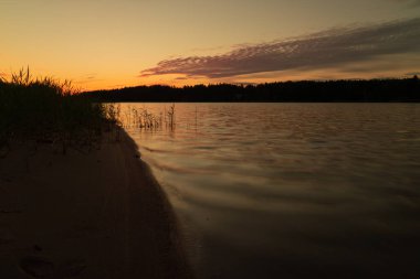 Denizde erken gün doğumu. Deniz suyuna yansıyan güneş ışınları. Suyun üzerinde parlıyor. Doğal deniz suyu arka planı. SANDINAVİYA 'NIN doğası. Finlandiya