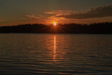 Denizde erken gün doğumu. Deniz suyuna yansıyan güneş ışınları. Suyun üzerinde parlıyor. Doğal deniz suyu arka planı. SANDINAVİYA 'NIN doğası. Finlandiya