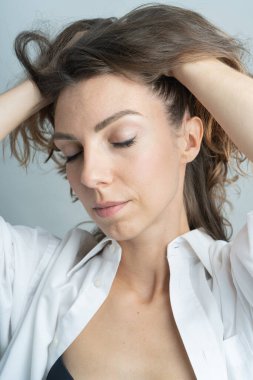 Model, esmer yakın plan. Stüdyoda. Beyaz bir gömlek giyiyor, siyah bir saç stili..