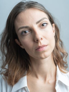 Model, esmer yakın plan. Stüdyoda. Beyaz bir gömlek giyiyor, siyah bir saç stili..