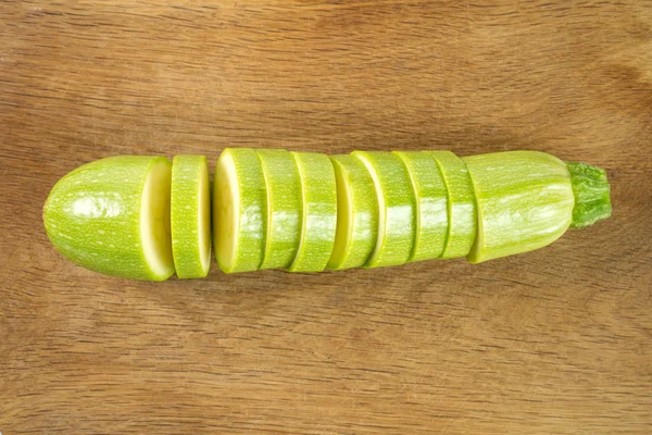 Zucchini isoliert auf einem hölzernen Hintergrund schneiden — Stockfoto