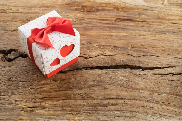 Geschenkdoos met twee rode harten aan kant op houten achtergrond — Stockfoto