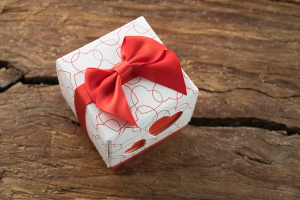Scatola regalo con due cuori rossi sul lato su sfondo di legno — Foto Stock