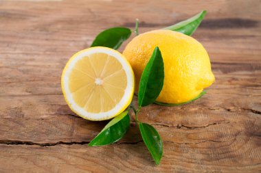 Ahşap arka plan üzerinde yaprakları ile taze limon
