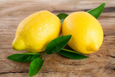 Ahşap arka plan üzerinde yaprakları ile taze limon