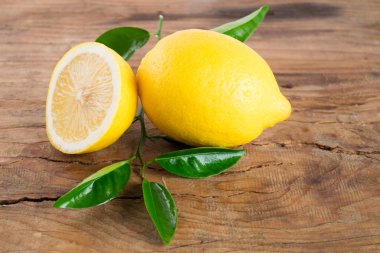 Ahşap arka plan üzerinde yaprakları ile taze limon