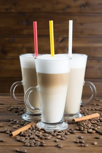 Latte med kaffe frön på trä bakgrund — Stockfoto