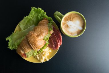 Kruvasan jambon, salam, marul, peynir, domates sarı ile