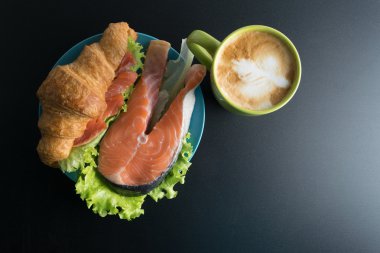 Kruvasan somon ve marul mavi plaka ve yeşil Kupası o