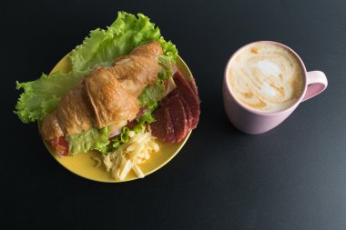 Kruvasan jambon, salam, marul, peynir, domates sarı ile