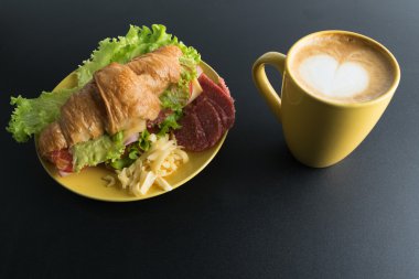 Kruvasan jambon, salam, marul, peynir, domates sarı ile