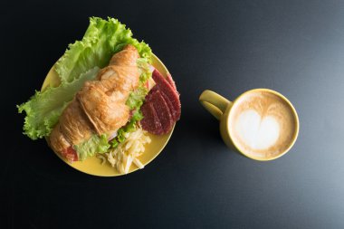 Kruvasan jambon, salam, marul, peynir, domates sarı ile