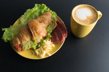 Kruvasan jambon, salam, marul, peynir, domates sarı ile