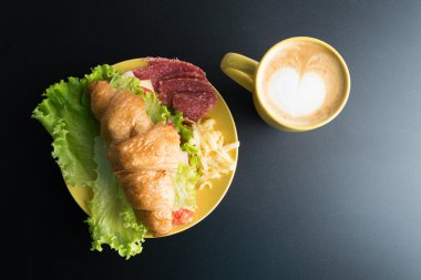 Kruvasan jambon, salam, marul, peynir, domates sarı ile