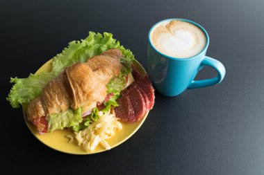 Kruvasan jambon, salam, marul, peynir, domates sarı ile