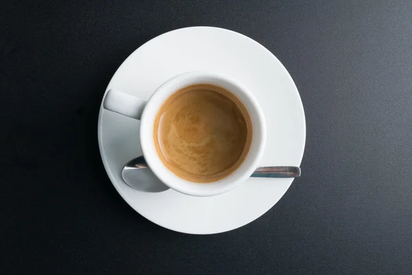 Witte kopje koffie geïsoleerd op zwarte achtergrond. Bovenaanzicht. — Stockfoto