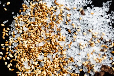 Siyah arka planda susam ve deniz tuzunun güzel bir karışımı.