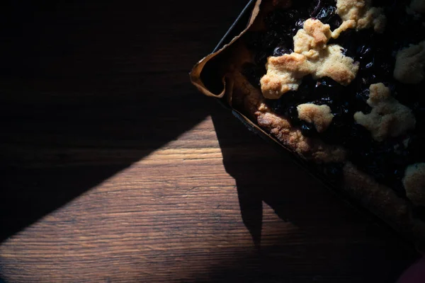 Black currant pie on a baking sheet, shortcrust pastry, low key — Stock Photo, Image