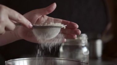 Un, küçük bir meta elek yoluyla eleme, yakın, makro, kadın elleri