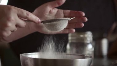 Un, küçük bir meta elek yoluyla eleme, yakın, makro, kadın elleri