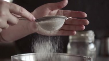 Un, küçük bir meta elek yoluyla eleme, yakın, makro, kadın elleri