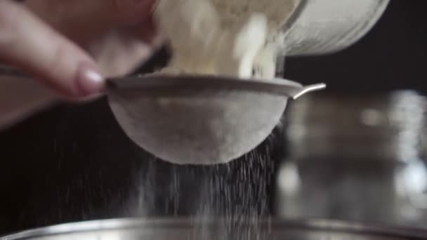 Peneirando farinha através de uma pequena peneira de metall, close-up, macro, mãos das mulheres — Vídeo de Stock