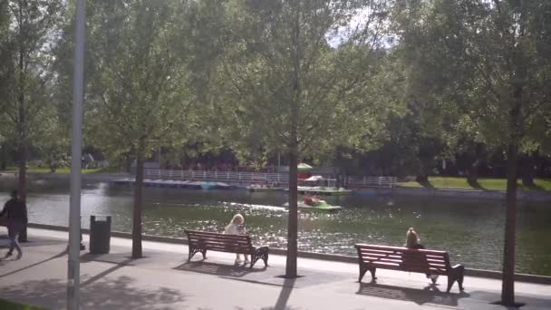 Burgers rusten op banken in de buurt van de Pioneer Pond op een zomeravond in Gorky Park — Stockvideo