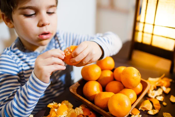 Cuatro años chico comer una mandarina — Foto de Stock