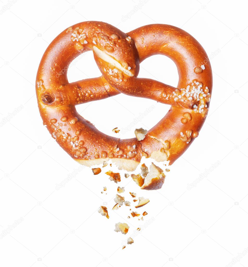 Freshly baked pretzel broken in the air on a white background 