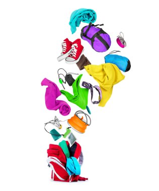 Kırmızı sırt çantasından çıkan çeşitli seyahat aksesuarları, beyaz arka planda izole edilmiş.