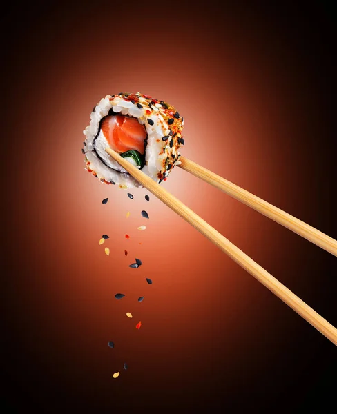 Sushi Japonés Tradicional Fresco Con Salmón Sésamo Entre Palillos Sobre — Foto de Stock