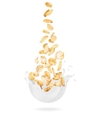 Mısır gevrekleri beyaz arka planda izole edilmiş süt damlalarına dökülüyor.