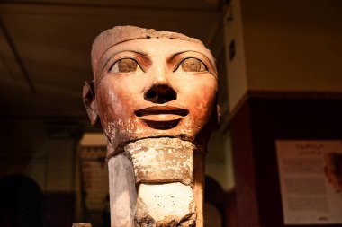 Kahire, Mısır; 21 Ocak 2024: Kahire 'deki Mısır Müzesi' nde Antik Mısır boyalı heykel kafası sergilendi. Heykelde, kraliyet veya elit bir figürü temsil eden ideal yüz özellikleri, özgün pigmentlerin ana hatları ve kalıntıları yer alıyor.