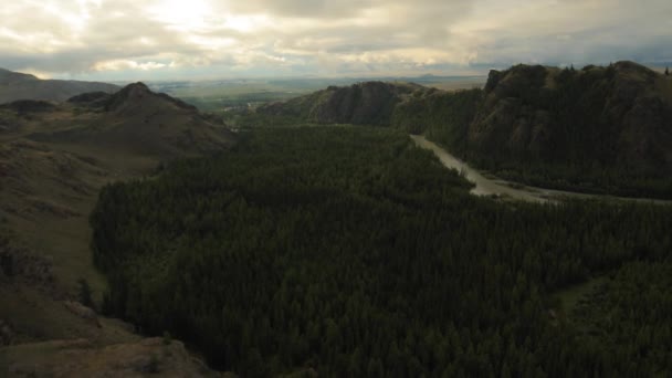 Voler par temps nuageux au-dessus de la rivière, la forêt et les montagnes 