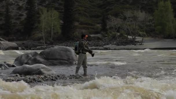 Pescadores en las piedras atrapan peces en el agua áspera . — Vídeos de Stock