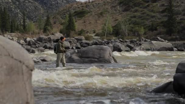 Vissers op de stenen vangen vis in het ruwe water. — Stockvideo