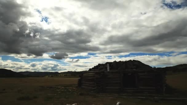 Белые облака на голубом небе над маленьким деревянным домом . — стоковое видео