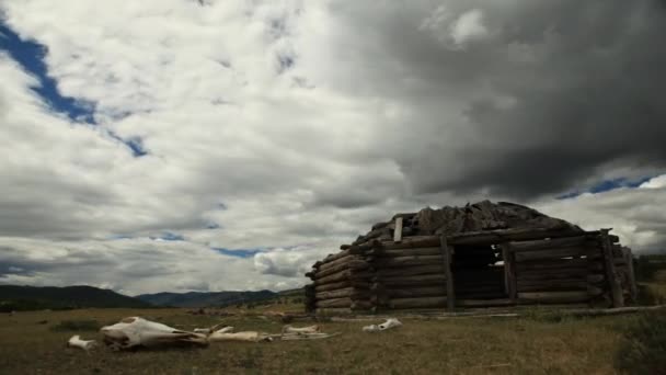 Weiße Wolken am blauen Himmel über dem kleinen Holzhaus. — Stockvideo