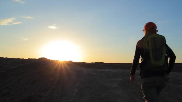 Giovane ragazza che cammina attraverso i canyon al tramonto — Video Stock